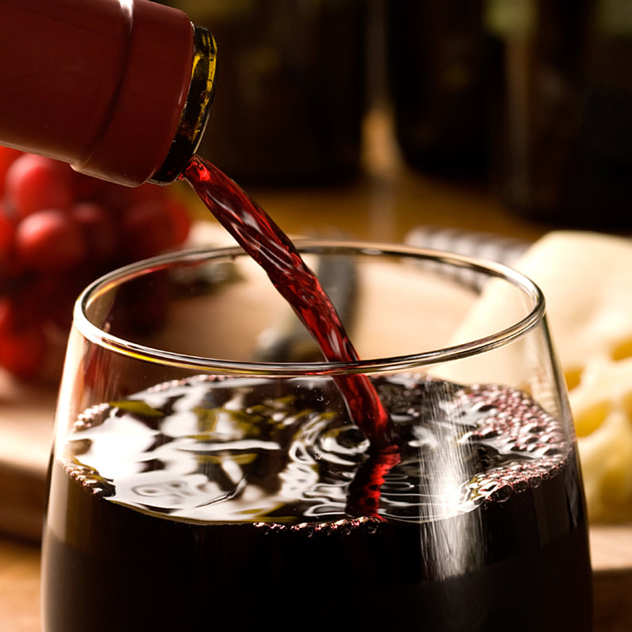 A glass of red wine being poured